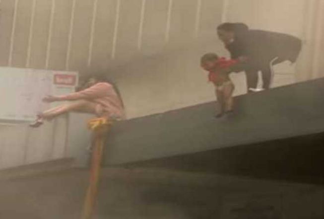 To save the daughter from the fire in the building, the mother threw the innocent girl down from the building