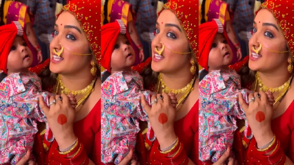 Amrapali Dubey, laden with gold jewelery in the bride's couple, is seen feeding the child in the lap